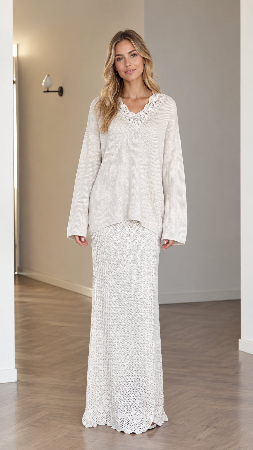 Front view of model wearing cream crochet V-neck sweater and matching knit maxi skirt set