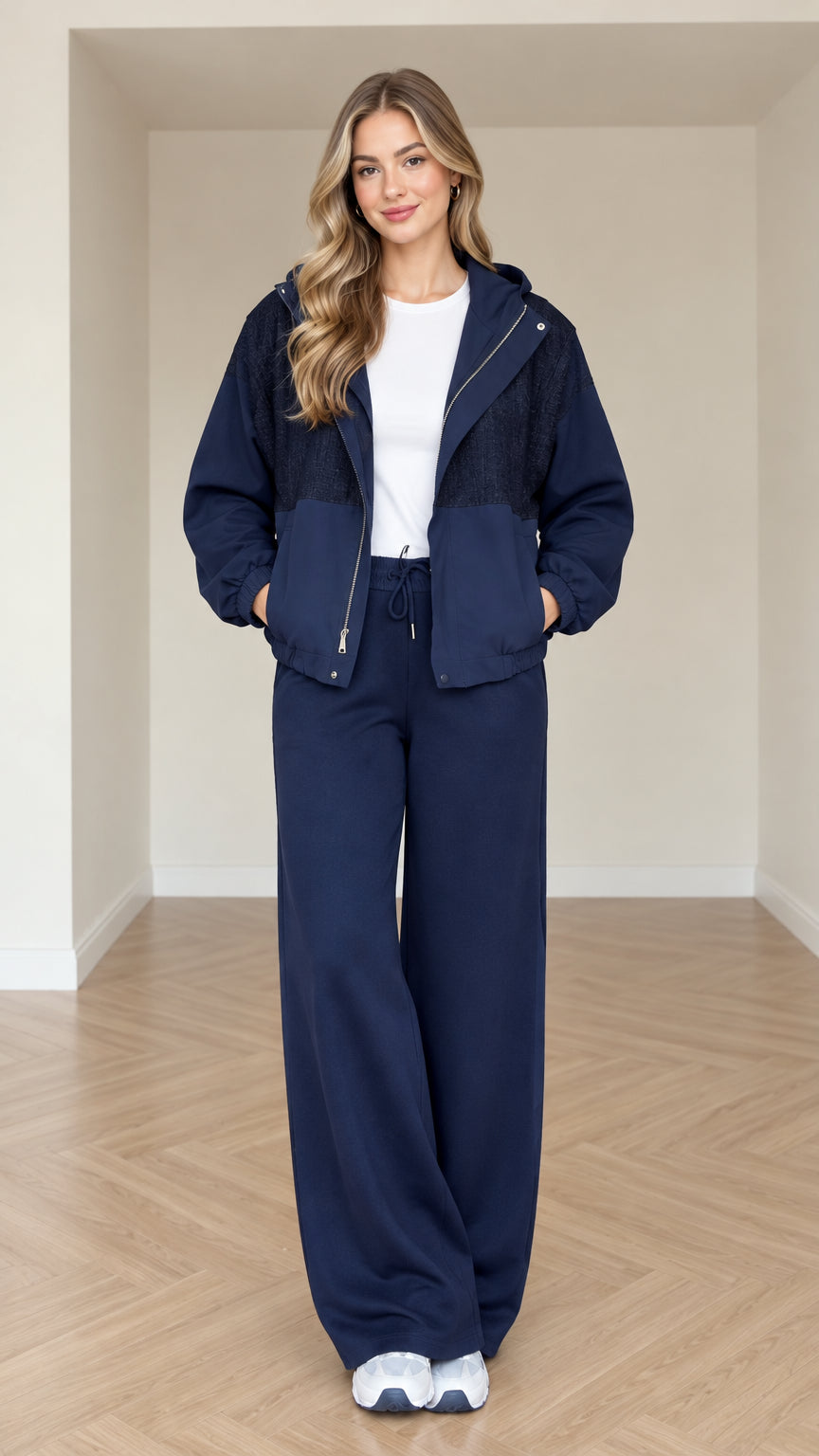 Model wearing navy blue women's hooded zip-up jacket and wide-leg pants set front view