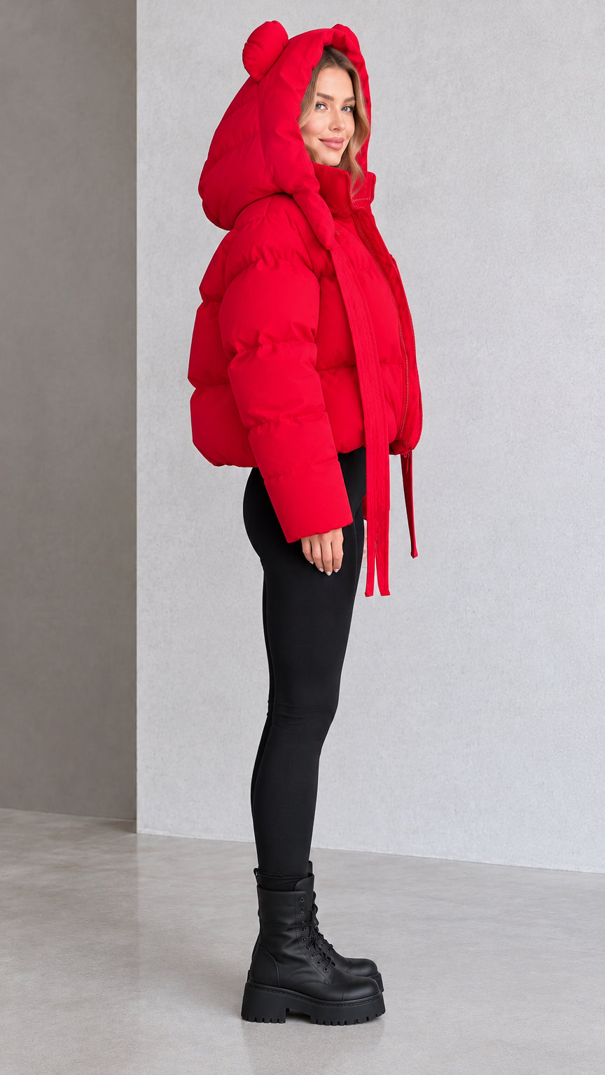 Side profile view of red bear ear cropped puffer jacket paired with black leggings