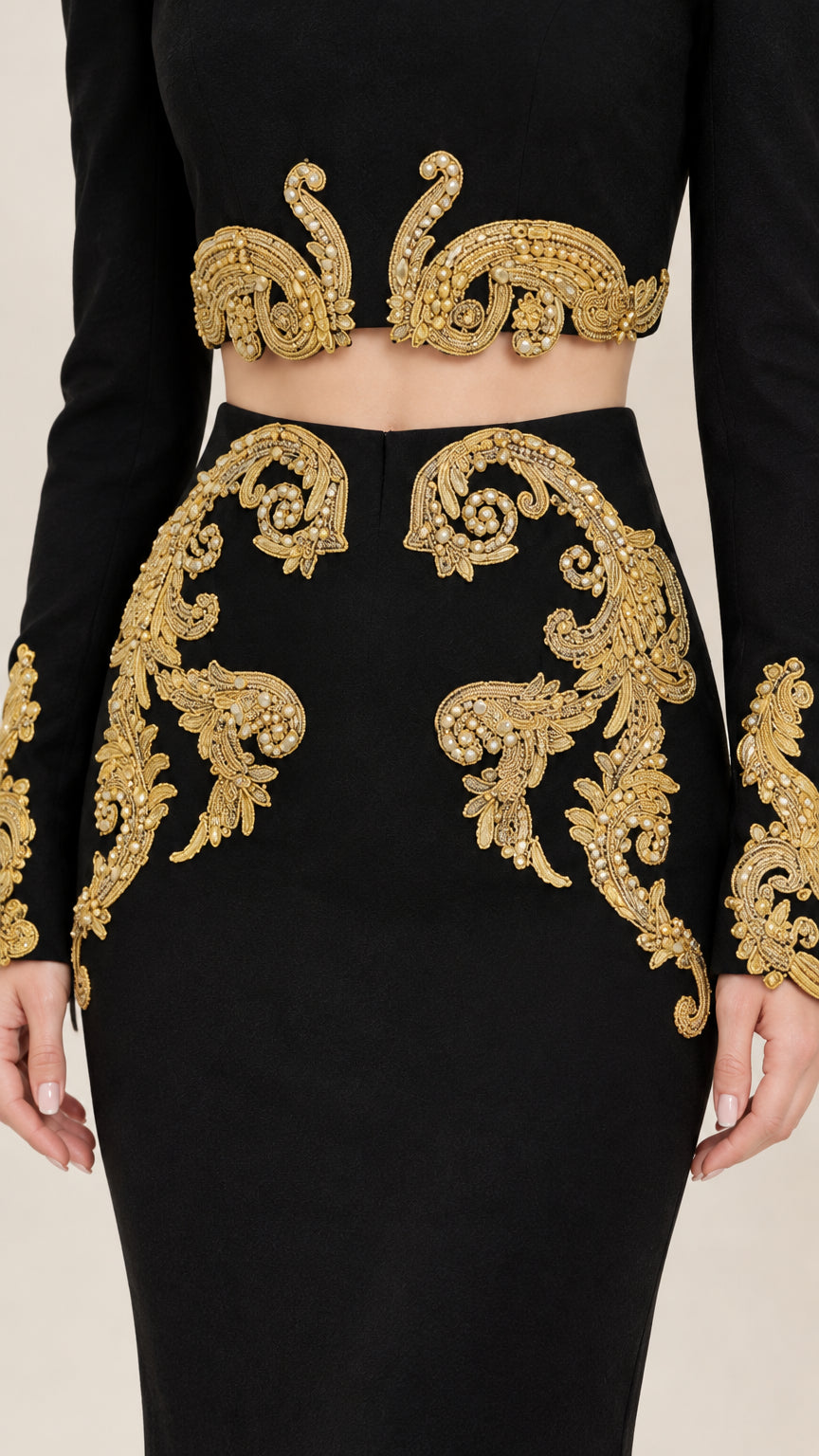 Close-up detail of ornate gold baroque embroidery on crop top hem and skirt waist