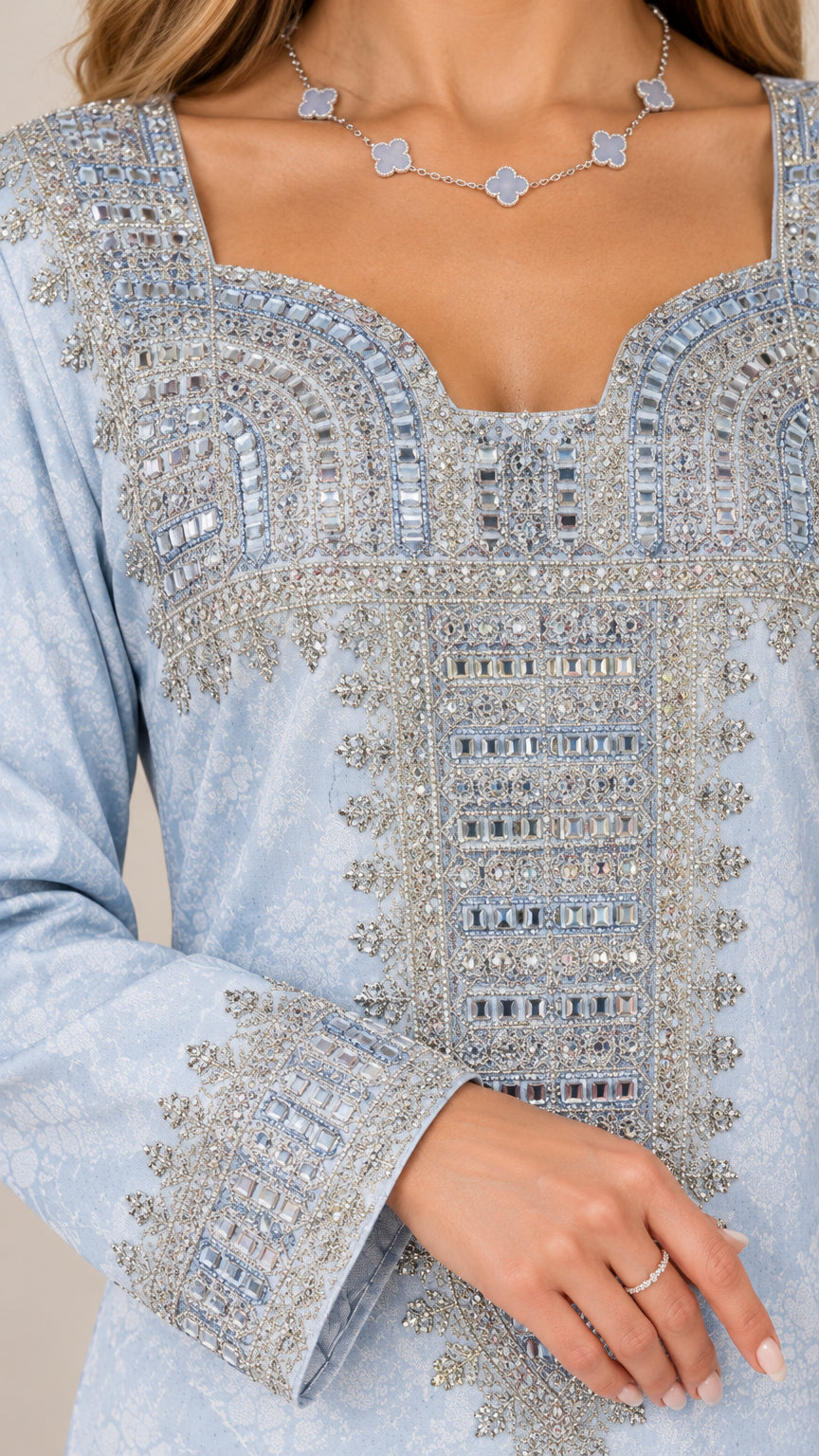 Close-up of intricate metallic embroidery and beading on neckline and cuff