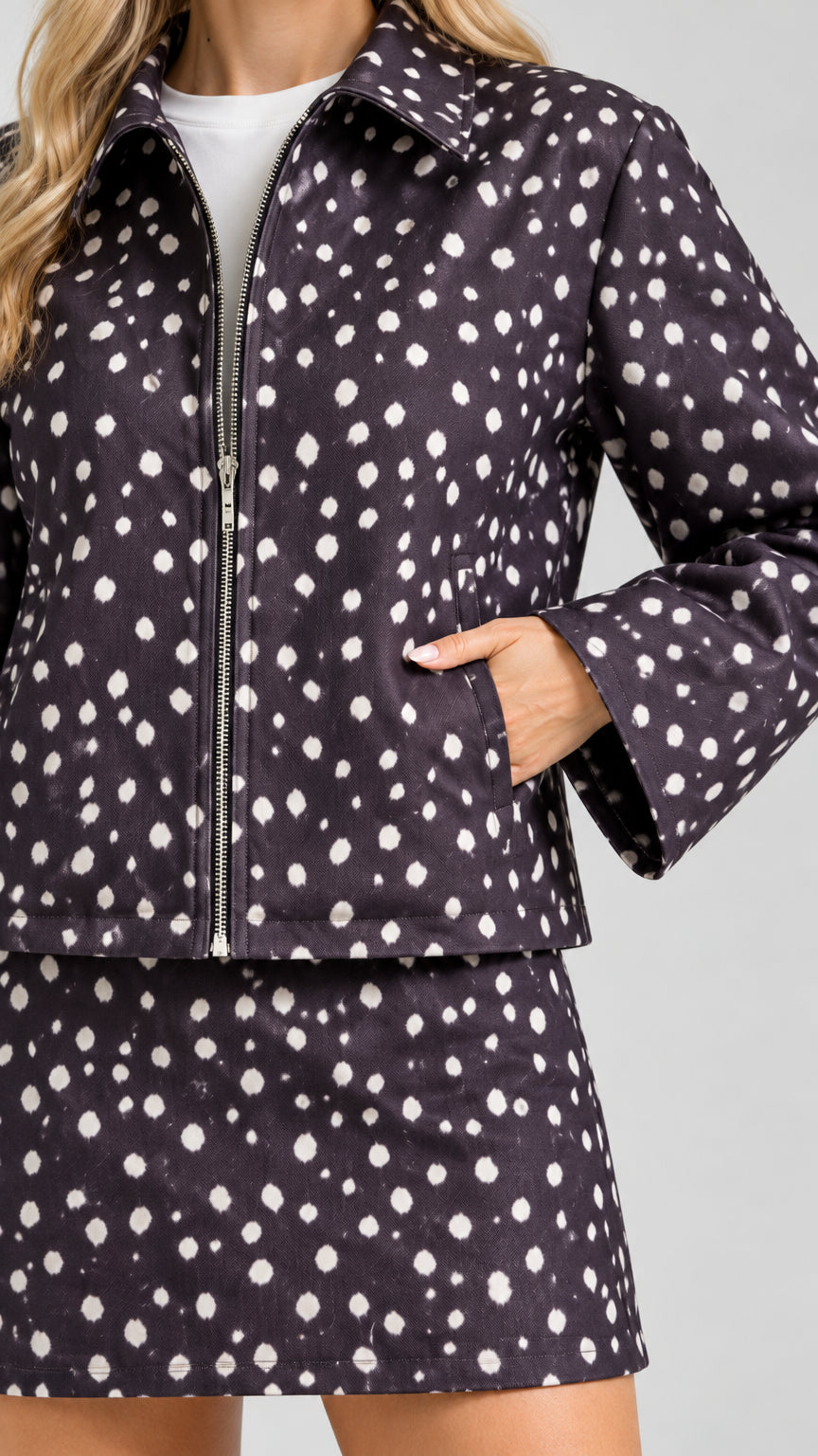 Close-up detail of zip-up jacket pocket and pattern on black polka dot set