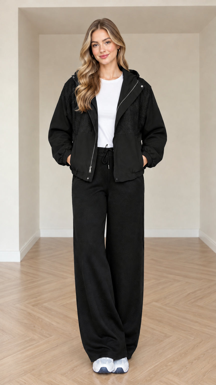 Model wearing black women's hooded jacket and wide-leg matching set