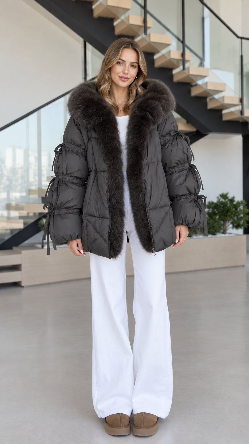 Women's charcoal faux fur hooded puffer jacket front view styled with white wide-leg pants