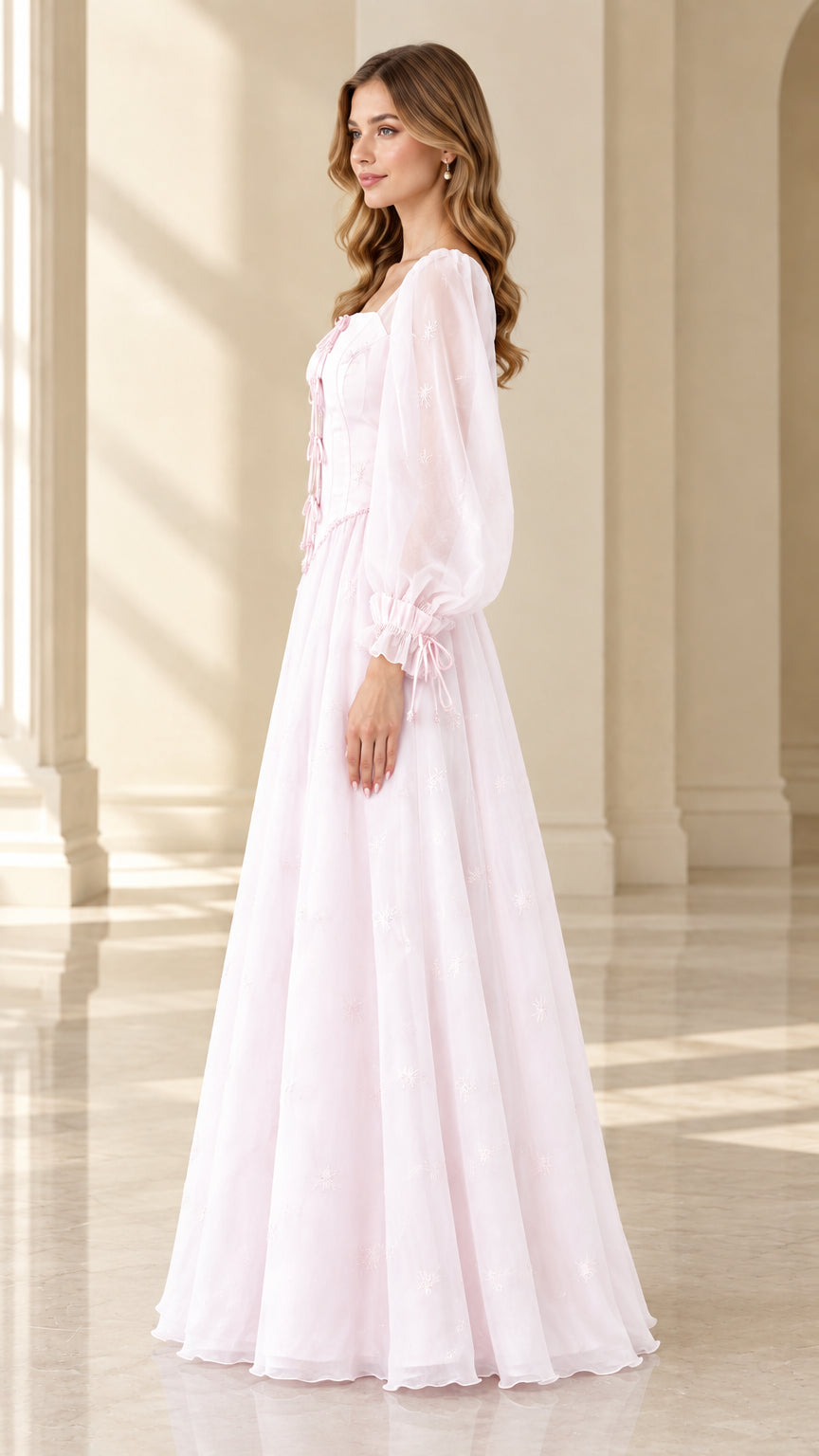 Side profile of woman wearing light pink romantic A-line embroidered maxi gown