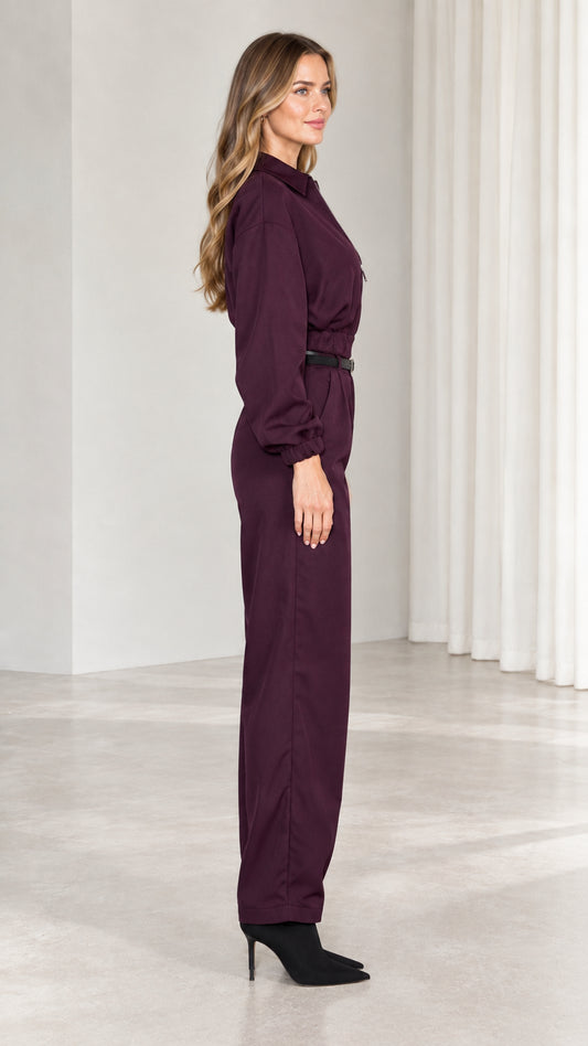 Side profile view of burgundy belted utility jumpsuit with long sleeves
