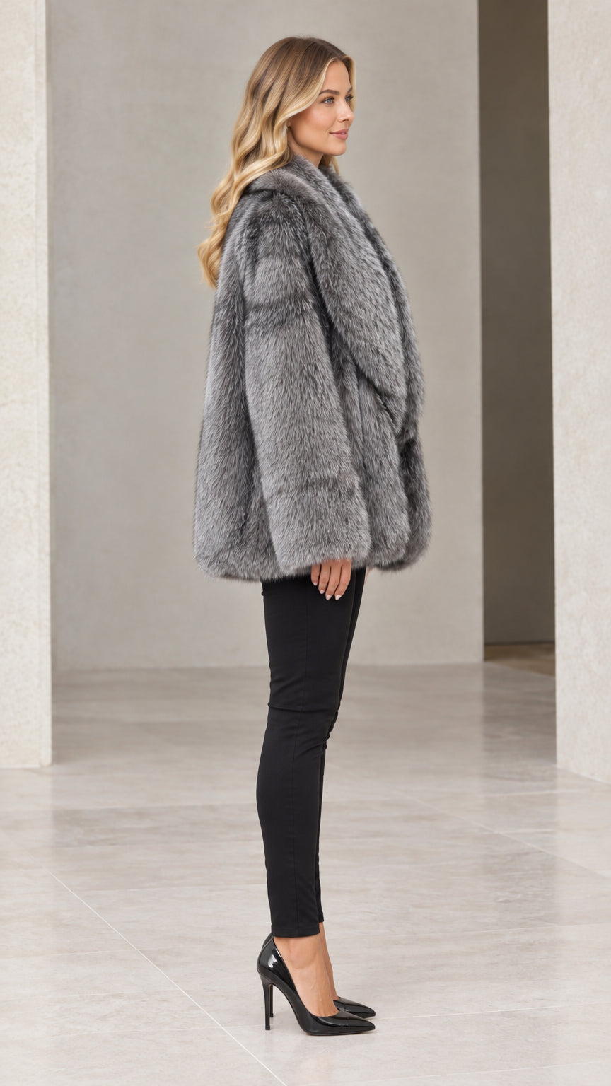 Side profile view of woman wearing silver grey mid-length faux fur coat
