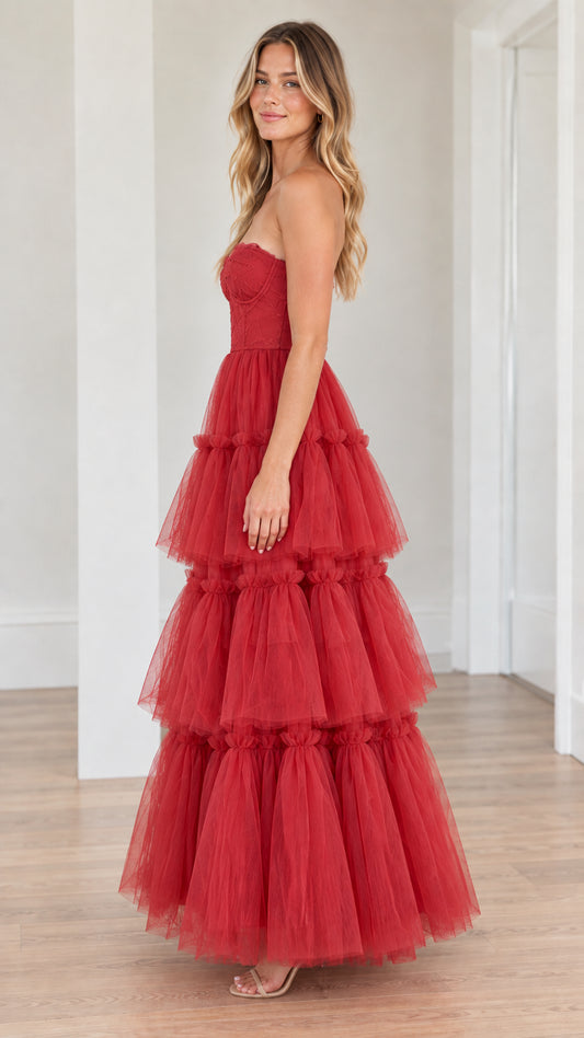 Side angle of strapless red tiered tulle formal gown