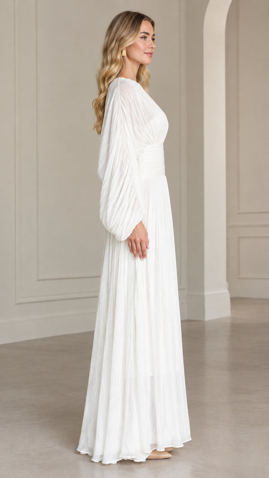 Side profile of woman in white balloon sleeve pleated maxi dress