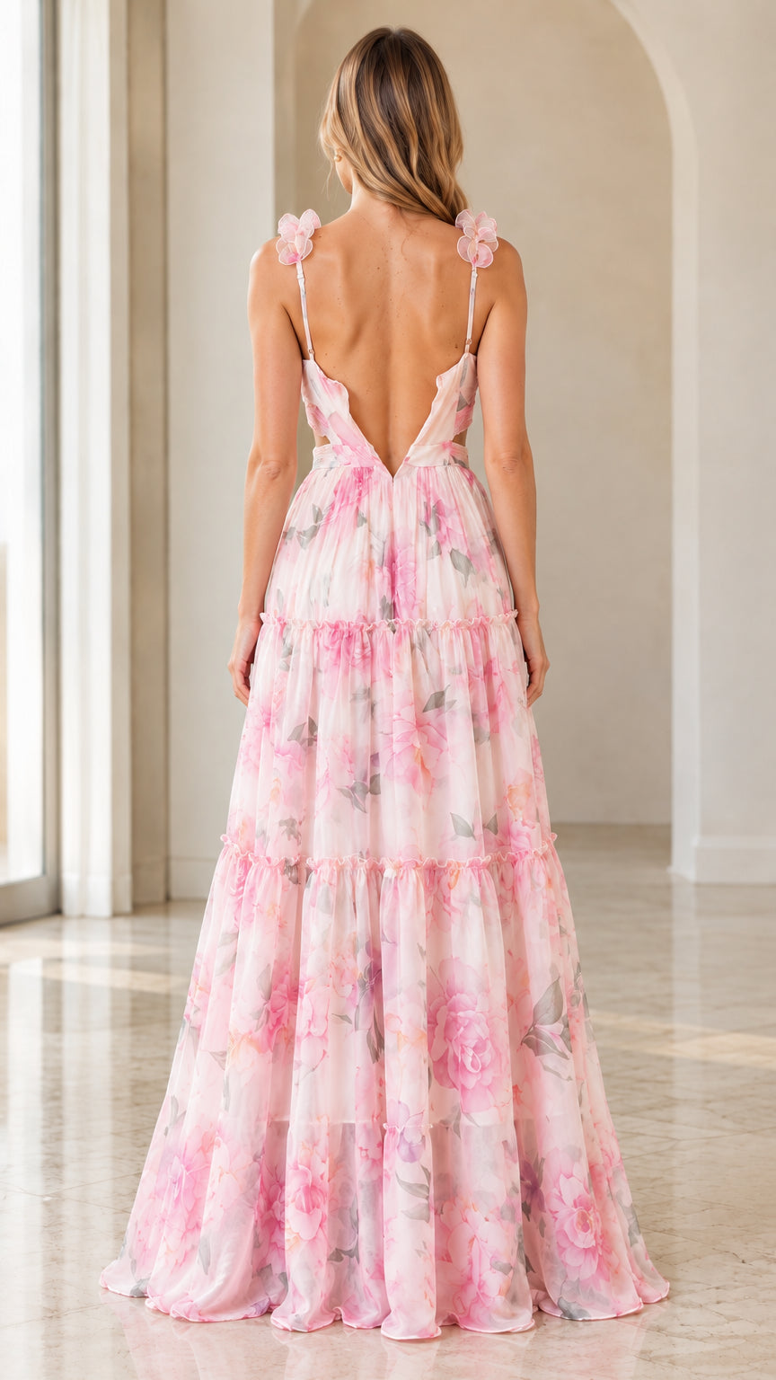 Back view of woman showing low V-back and flowing tiered skirt on pink floral maxi dress