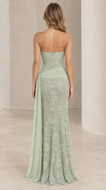 Back view of woman wearing strapless sage green formal gown with floor-length drape