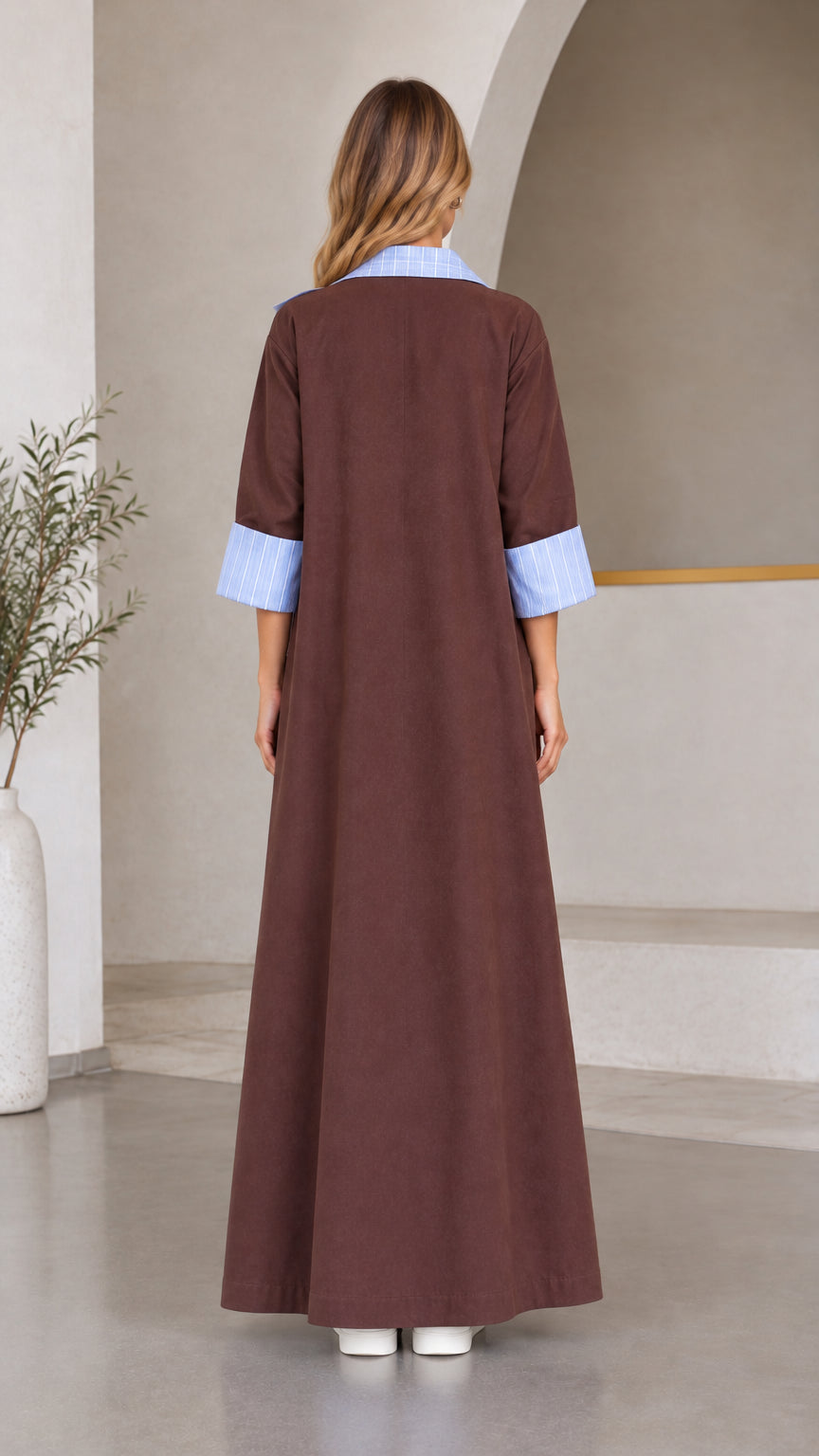Back view of women's floor-length brown duster coat with striped cuffed sleeves