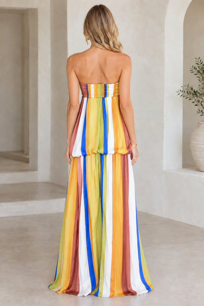 Back view of model in rust multicolor strapless striped maxi dress