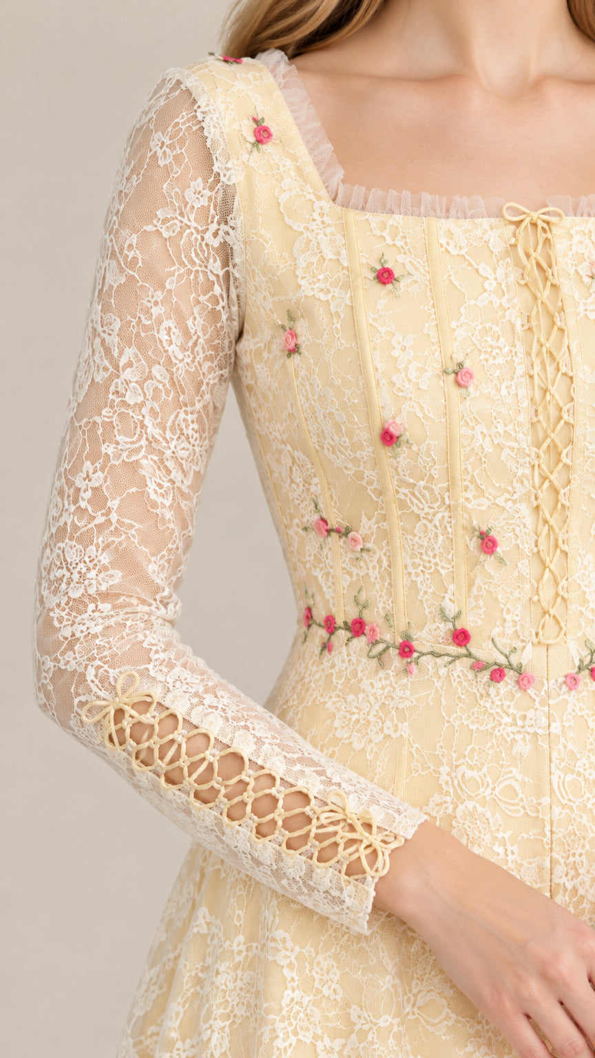 Close-up detail of floral embroidery, square neckline, and lace-up sleeve cuff