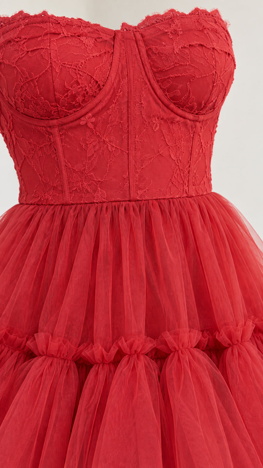 Close-up detail of red floral lace bodice and gathered tulle skirt