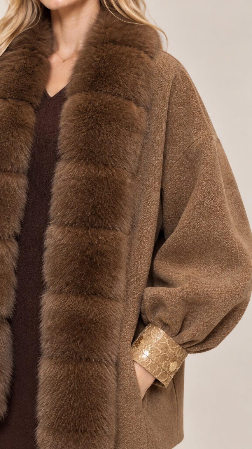 Close-up detail of plush faux fur collar and textured sleeve cuff in camel