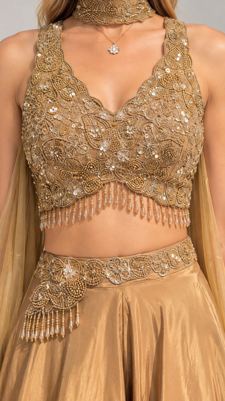 Close-up detail of gold sequin and beadwork on crop top with tassel fringe