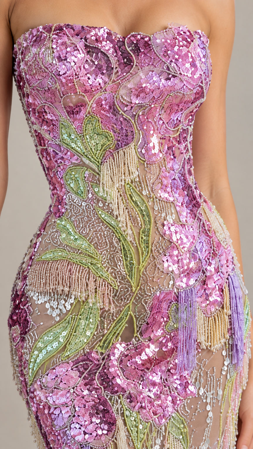 Close-up detail of pink and green floral sequin embroidery and beaded fringe accents