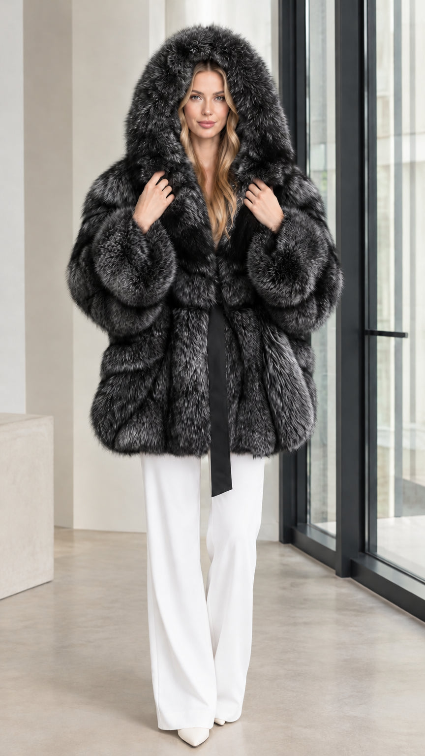 Charcoal black hooded belted faux fur coat worn with white trousers