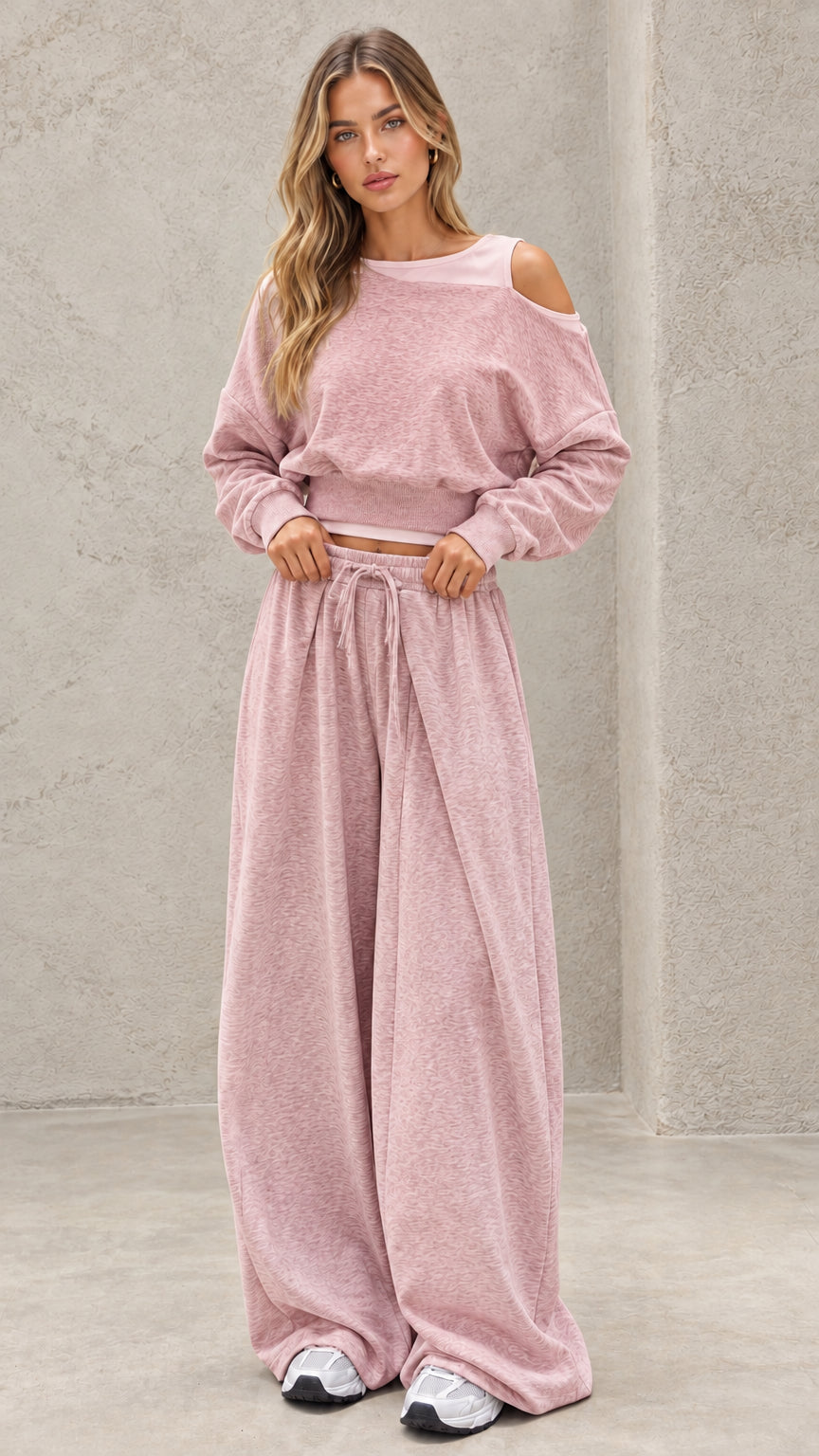 Full-length view of model wearing dusty pink cold shoulder cropped sweatshirt and wide leg pants set