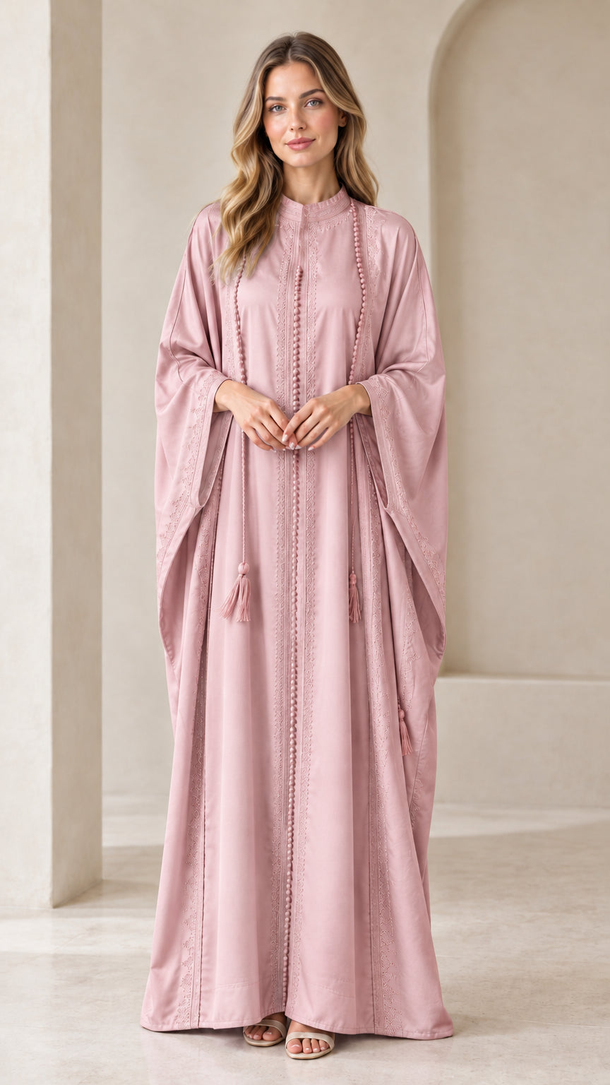 Front view of woman wearing Dusty Pink embroidered batwing kaftan maxi dress with tassels