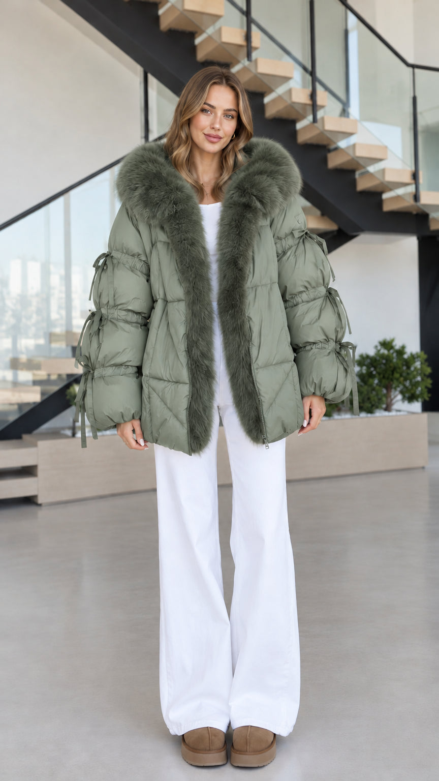 Women's sage green hooded puffer coat featuring faux fur trim and bow sleeve accents