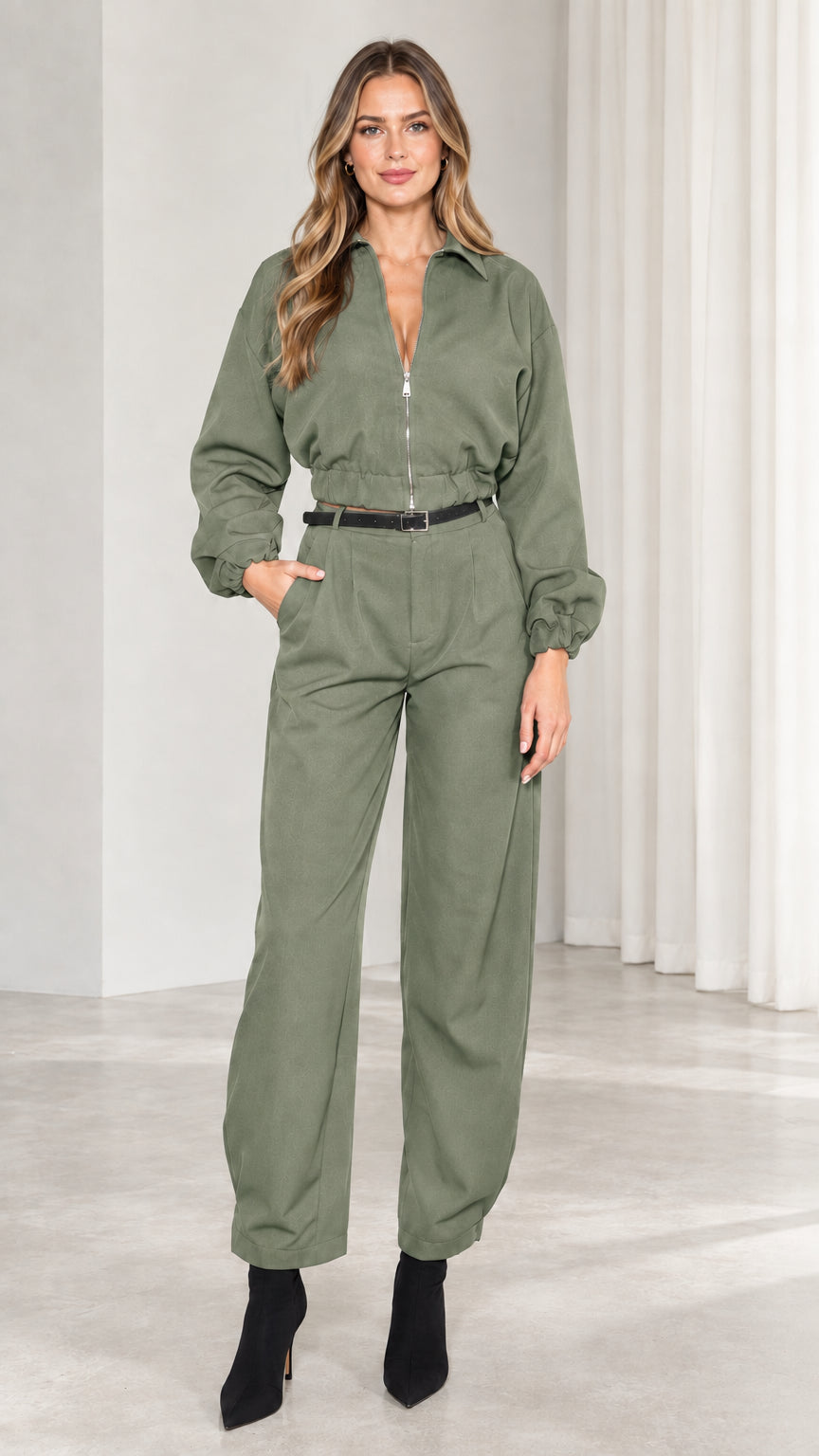 Front view of model wearing sage green long sleeve utility jumpsuit