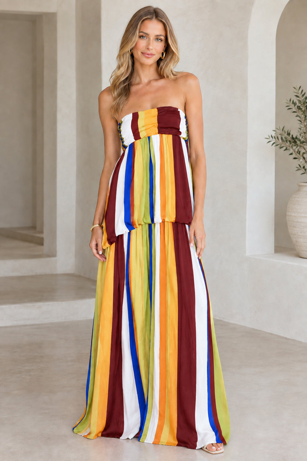 Model wearing burgundy multicolor strapless striped maxi dress