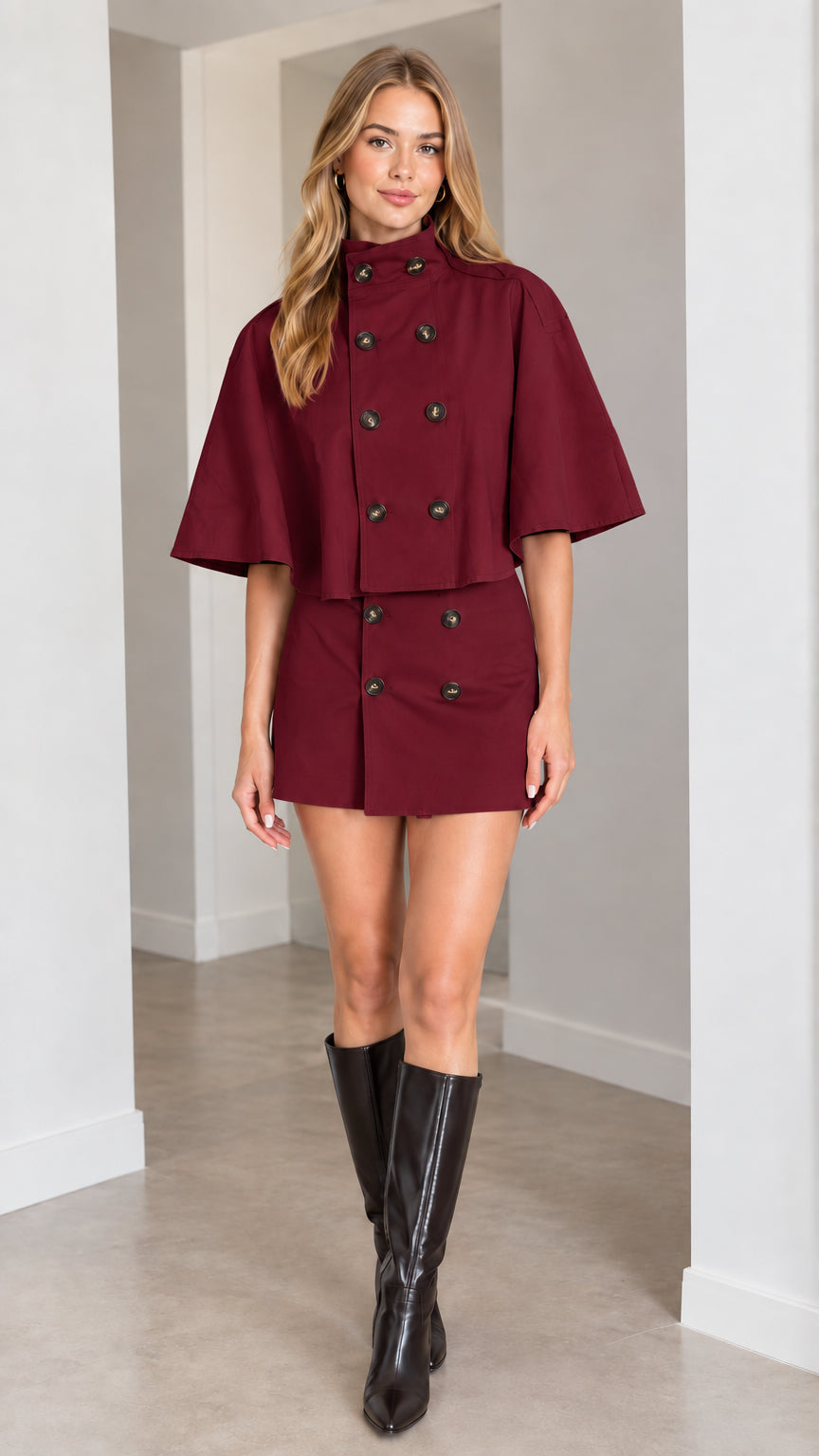 Model wearing burgundy wine red cape jacket and tailored mini skirt set