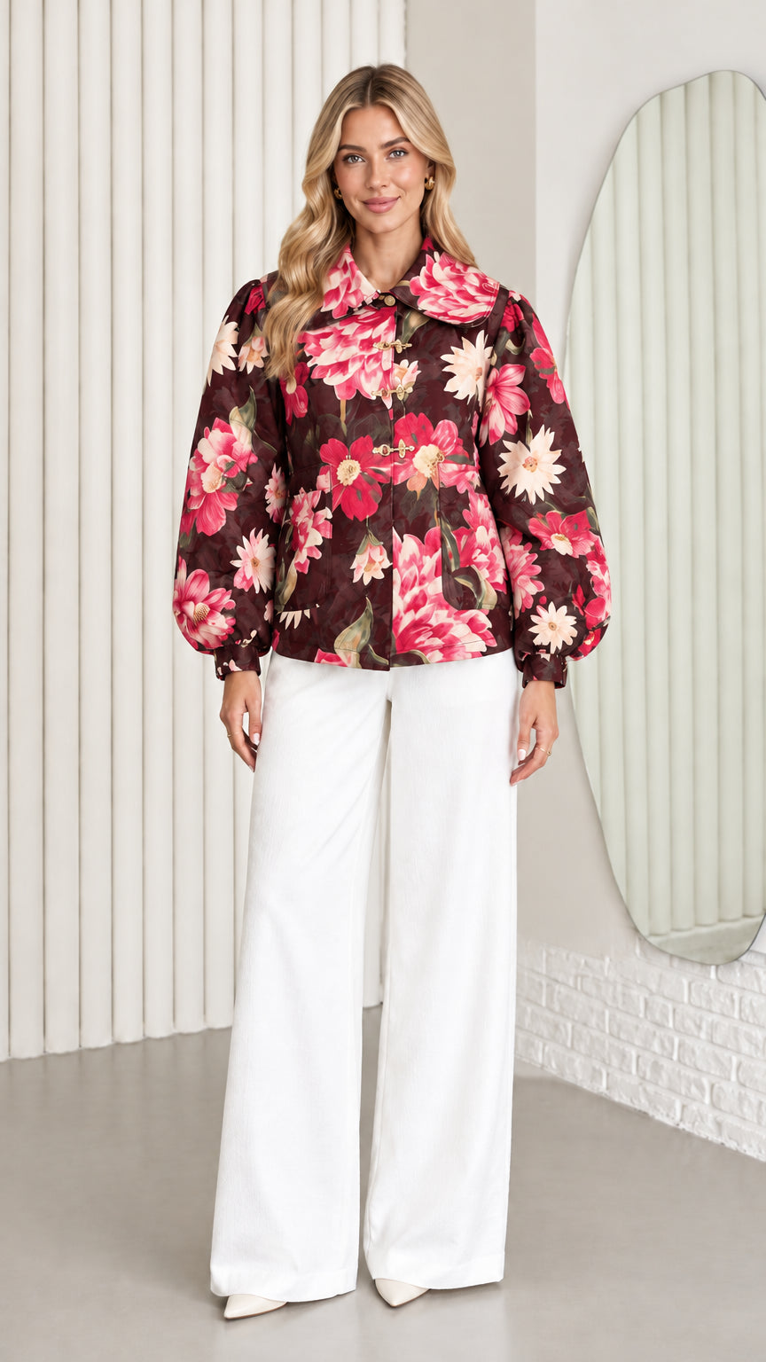 Front view of model wearing chocolate brown floral balloon sleeve jacket with white wide-leg trousers