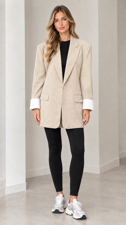 Front view of model wearing beige oatmeal pinstripe oversized blazer with white cuffs