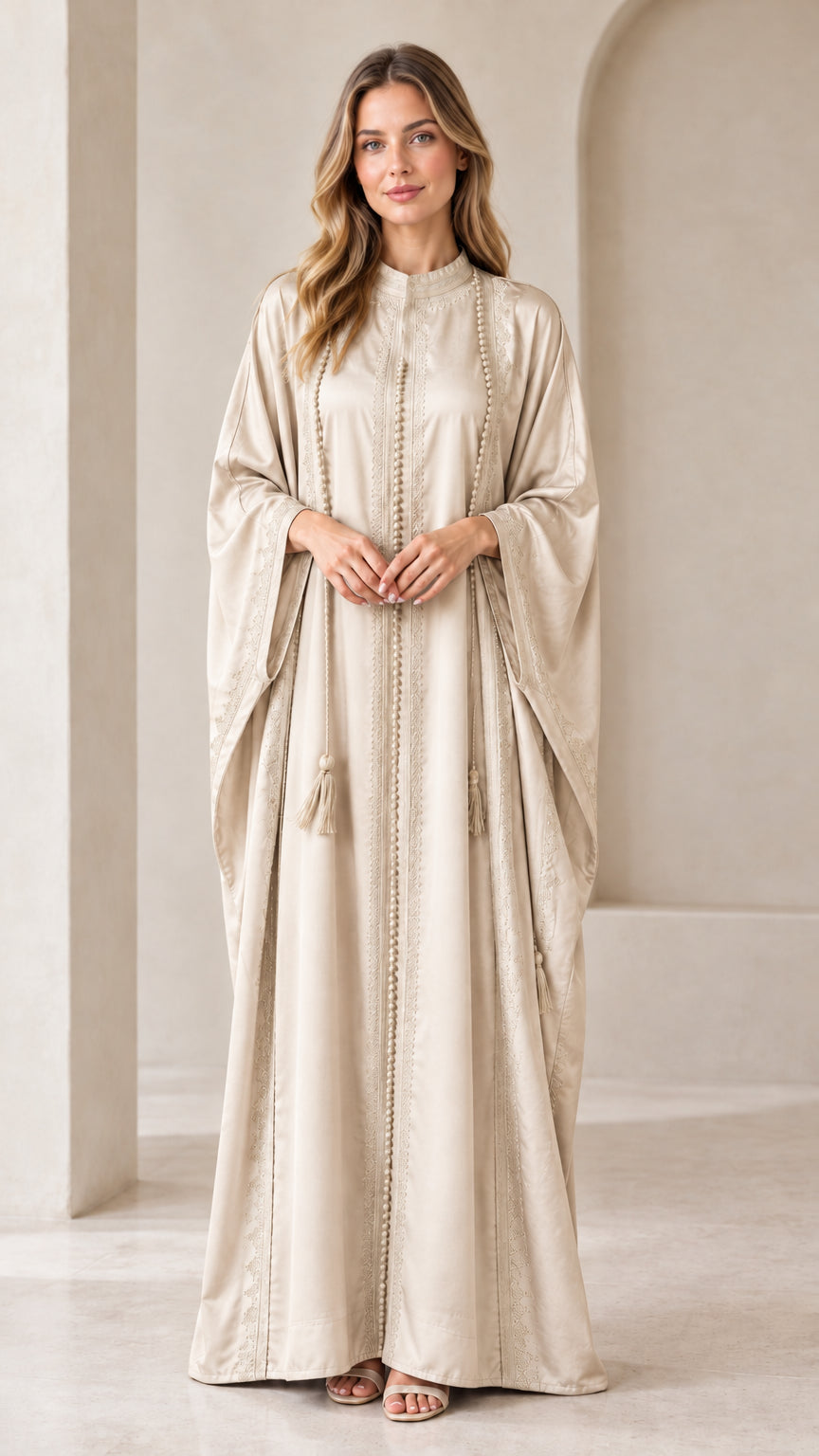 Front view of woman wearing Champagne beige embroidered batwing kaftan maxi dress with tassels